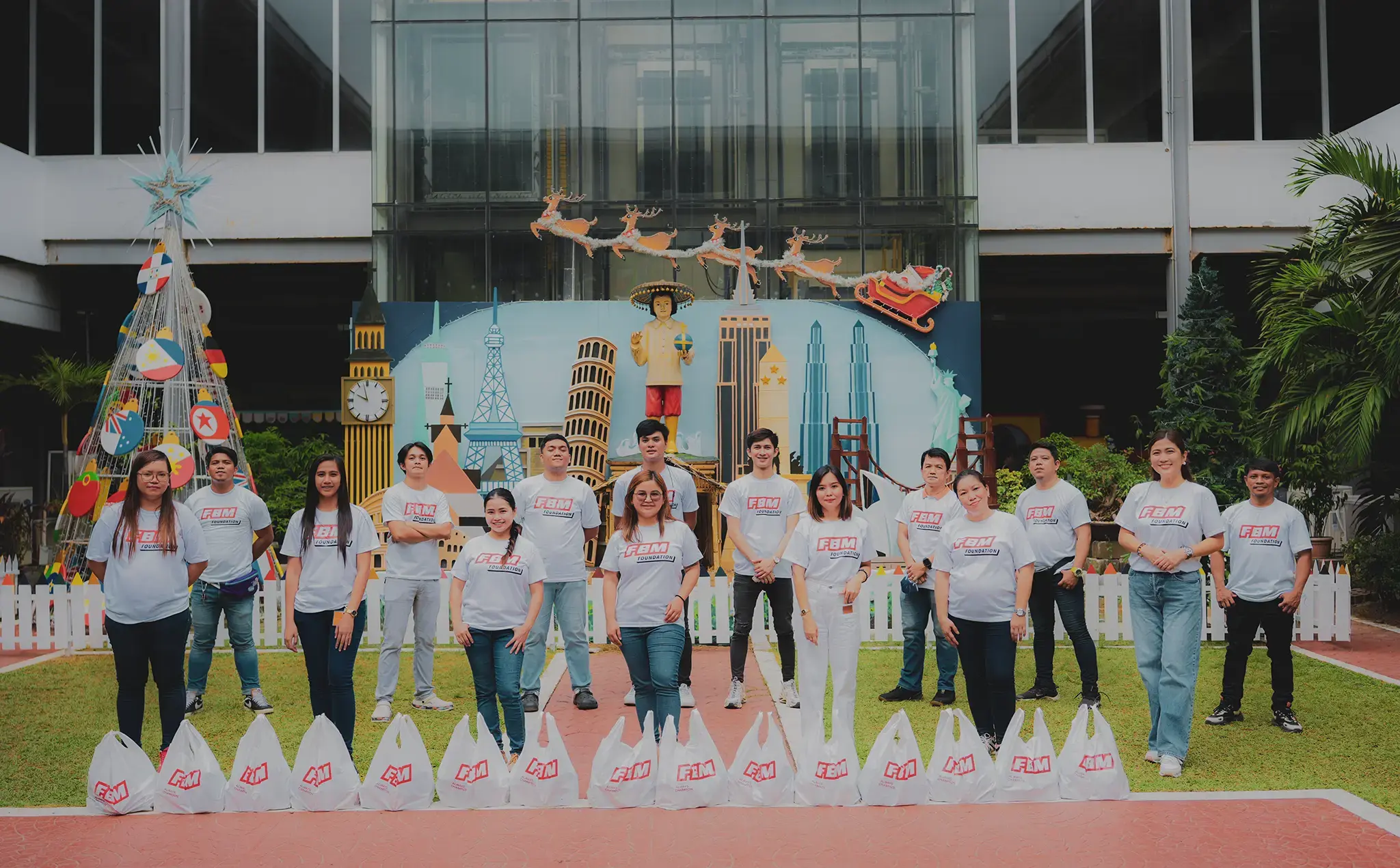 FBM Foundation volunteers posing for a photo with several goods donated in a solidarity action of the FBM group in the Philippines