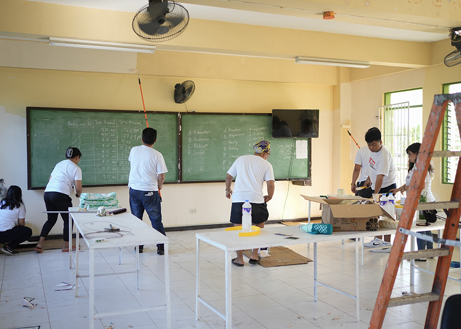 In this image you can see six FBM Foundation volunteers doing the renovation of a computer laboratory at Dr. Jose P. Rizal Senior High School