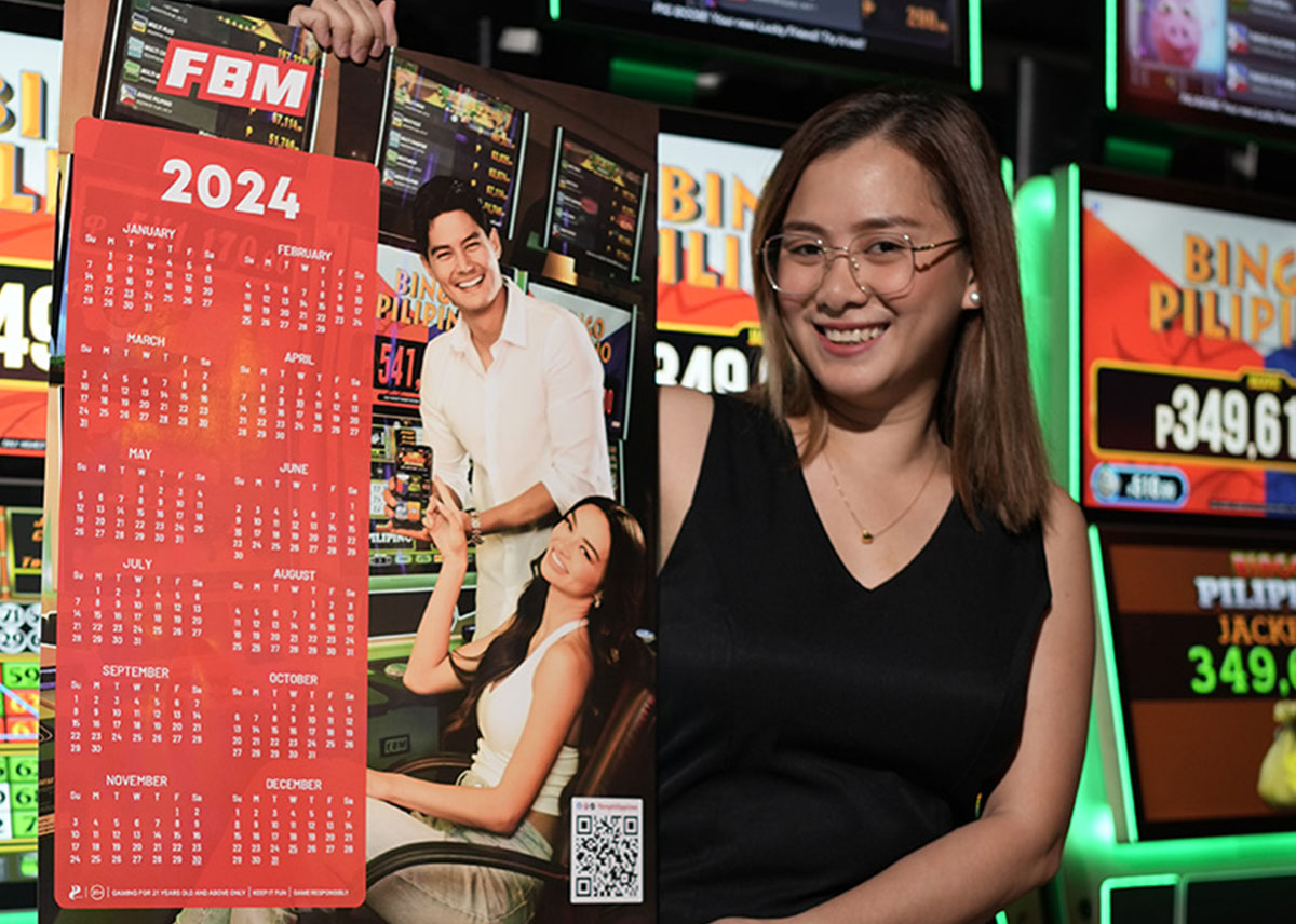 Esta imagen muestra a una promotora de FBM con un calendario que presenta a Daniel Matsunaga y Kylie Versoza, que la marca ofreció a sus jugadores.