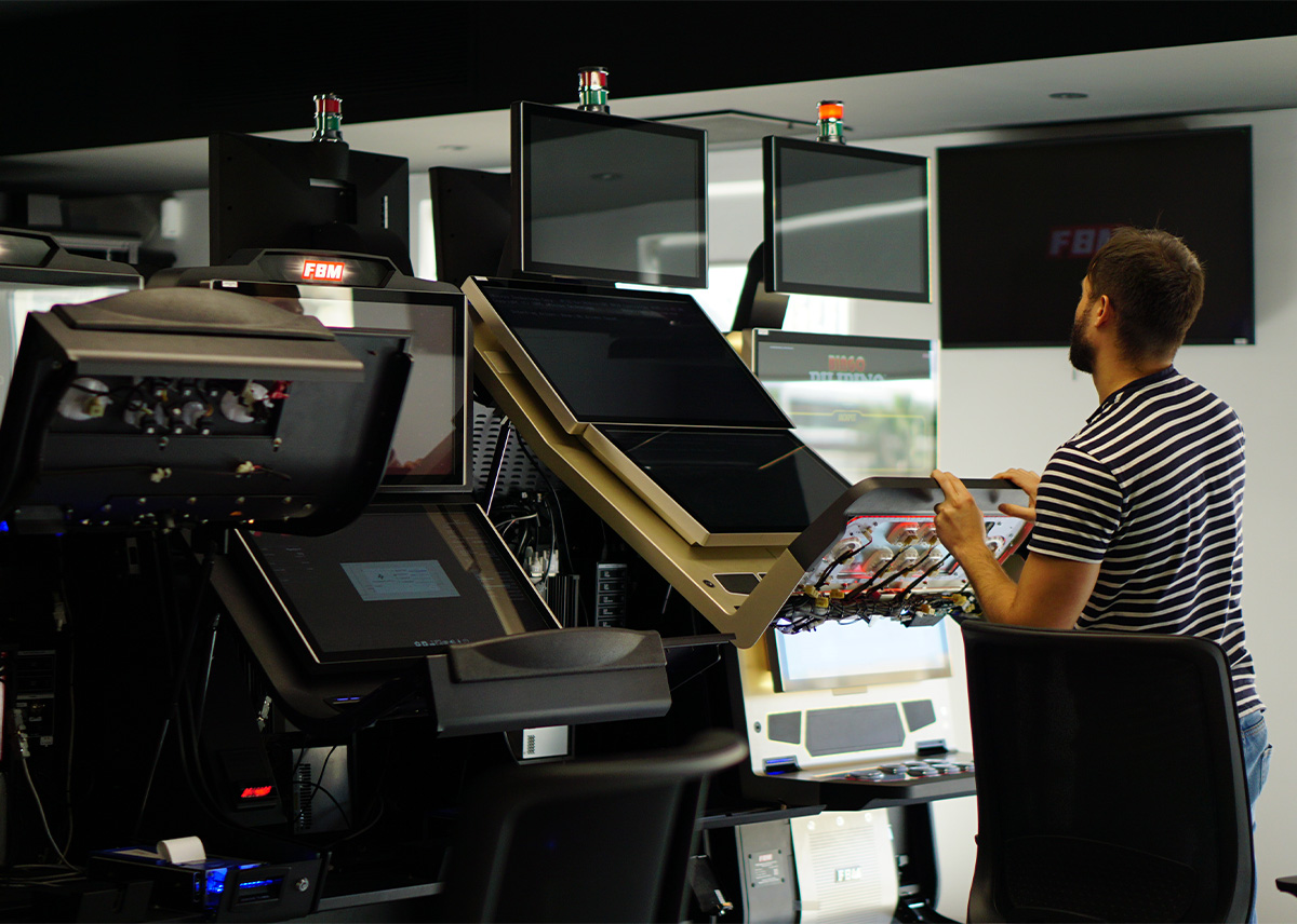 This image displays an FBM employee checking the components of one of the FBM casino cabinets.