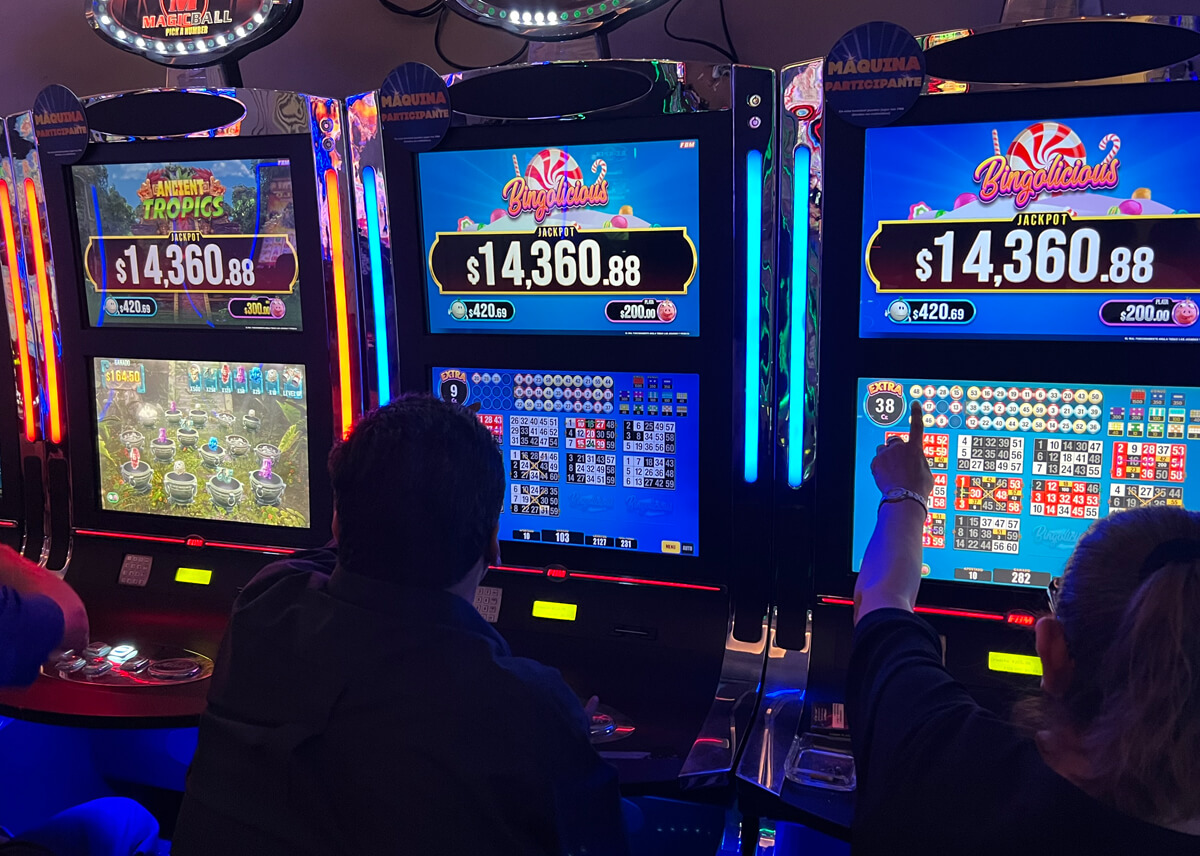 This image shows some players enjoying FBM video bingo games in different cabinets inside a Mexican casino room.