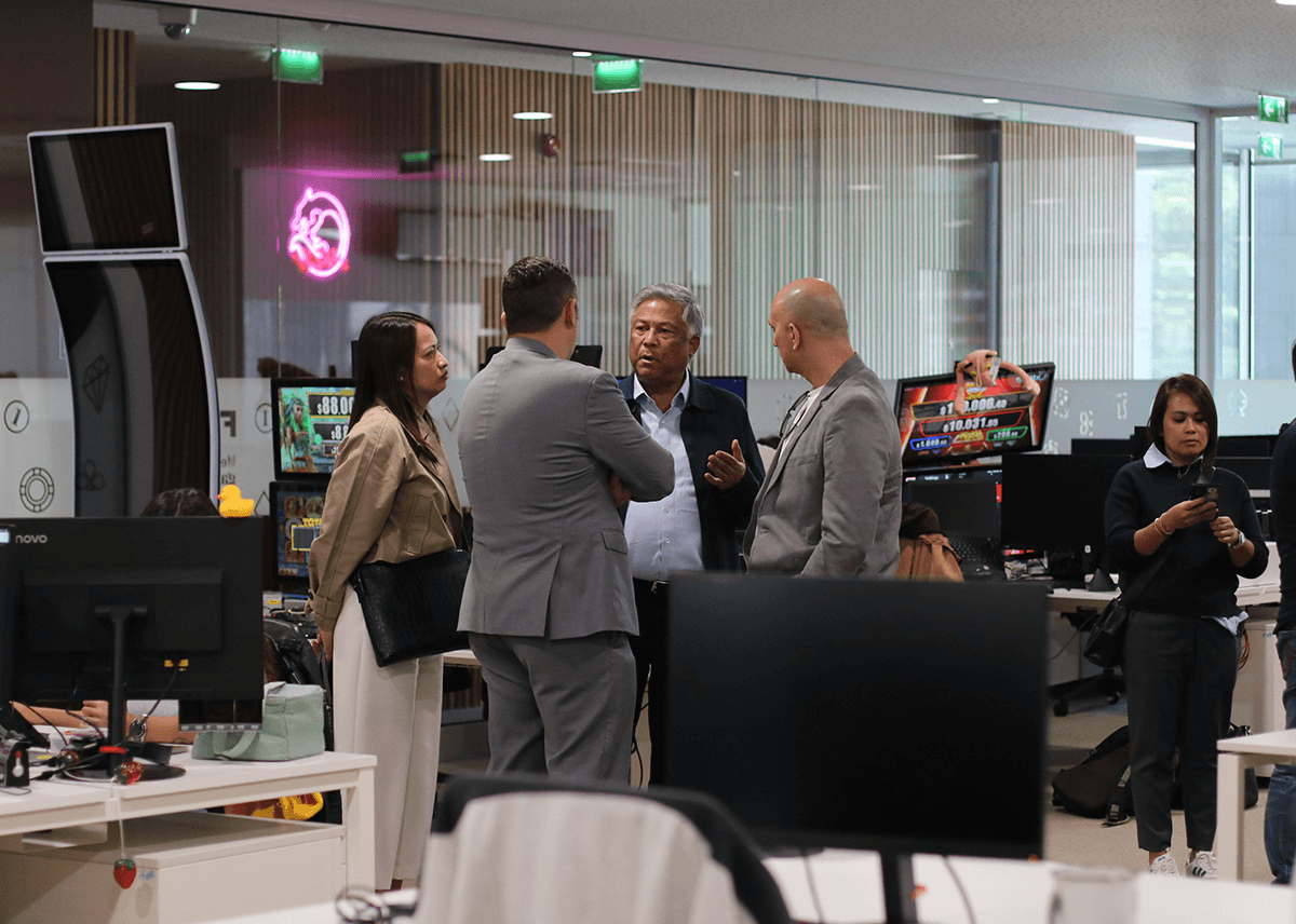 The image shows two FBM representatives with the PAGCOR delegation visiting FBM's software house in Portugal.