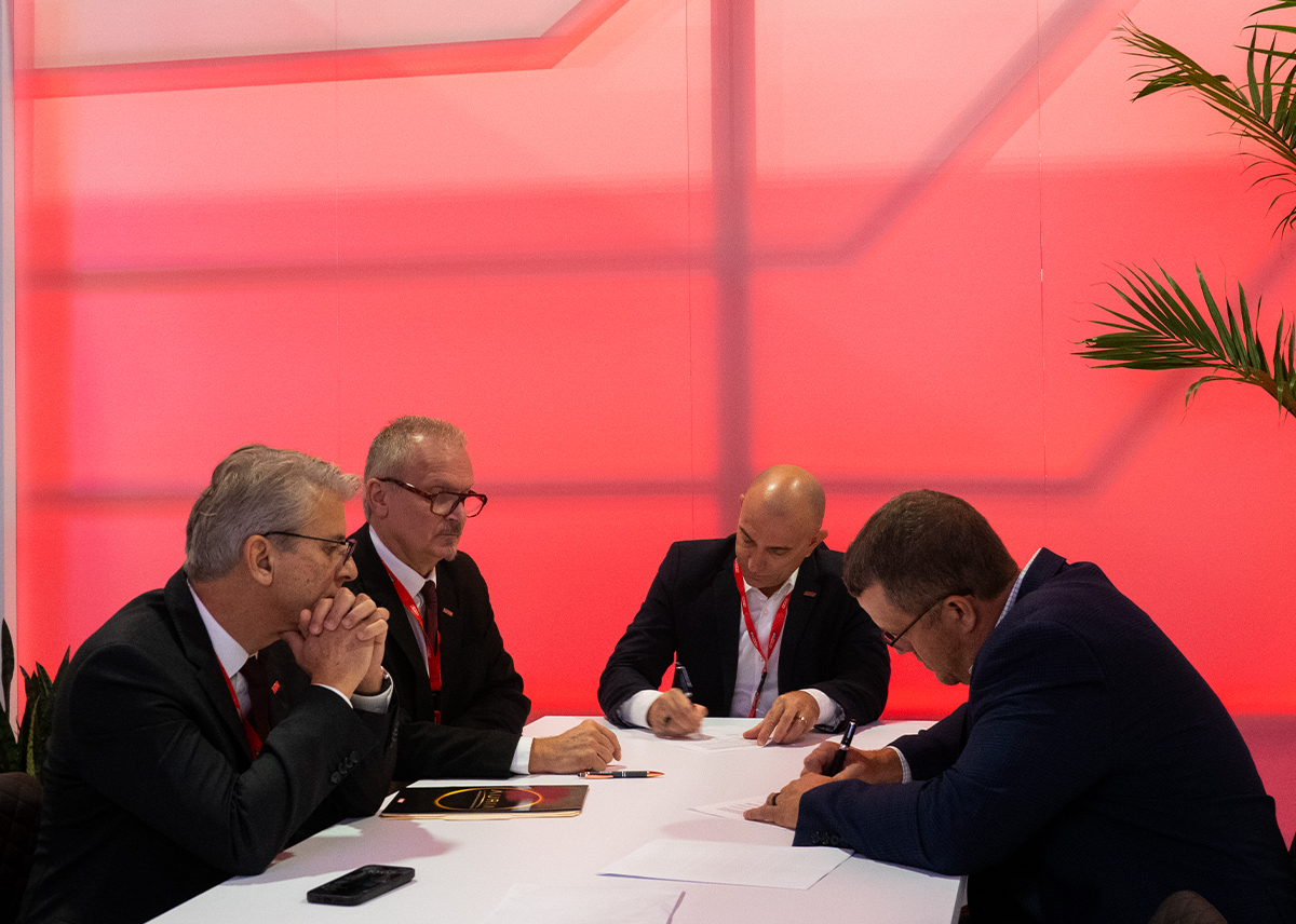 The image shows the FBM and Delta Gaming Solutions representatives at the table signing the distribution agreement for Oklahoma.