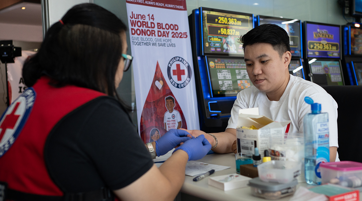 Donantes participando, equipo de la Cruz Roja Filipina, voluntarios sonrientes y foto grupal durante la jornada de donación de sangre organizada por FBM Foundation.