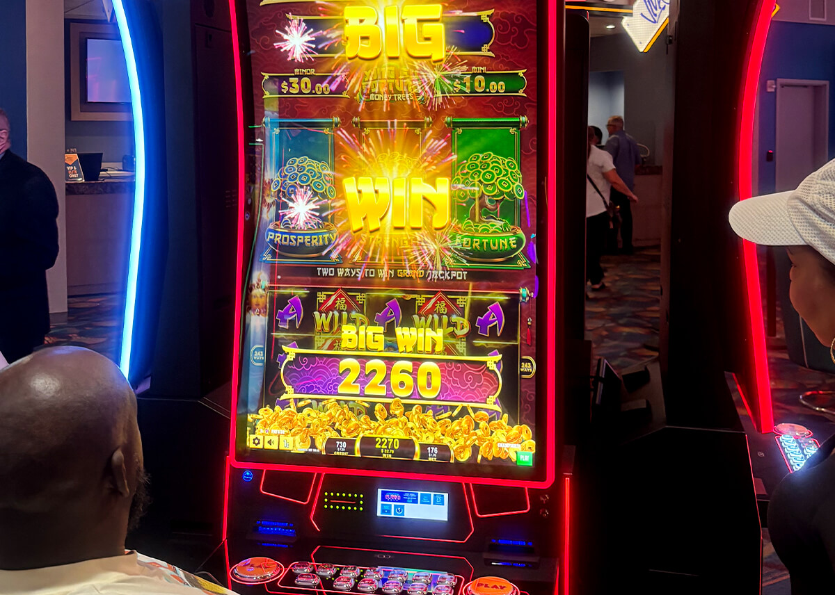 This image shows a player enjoying FBM's Xing Fú Fortune Money Trees slot at Casino Miami after its installation.