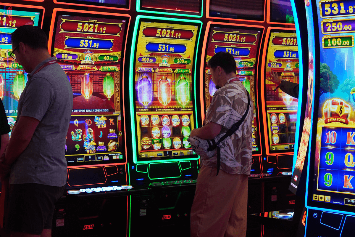 Esta imagen muestra a 2 jugadores verificando los detalles de los juegos de slots FBM Lanterns of Fú.